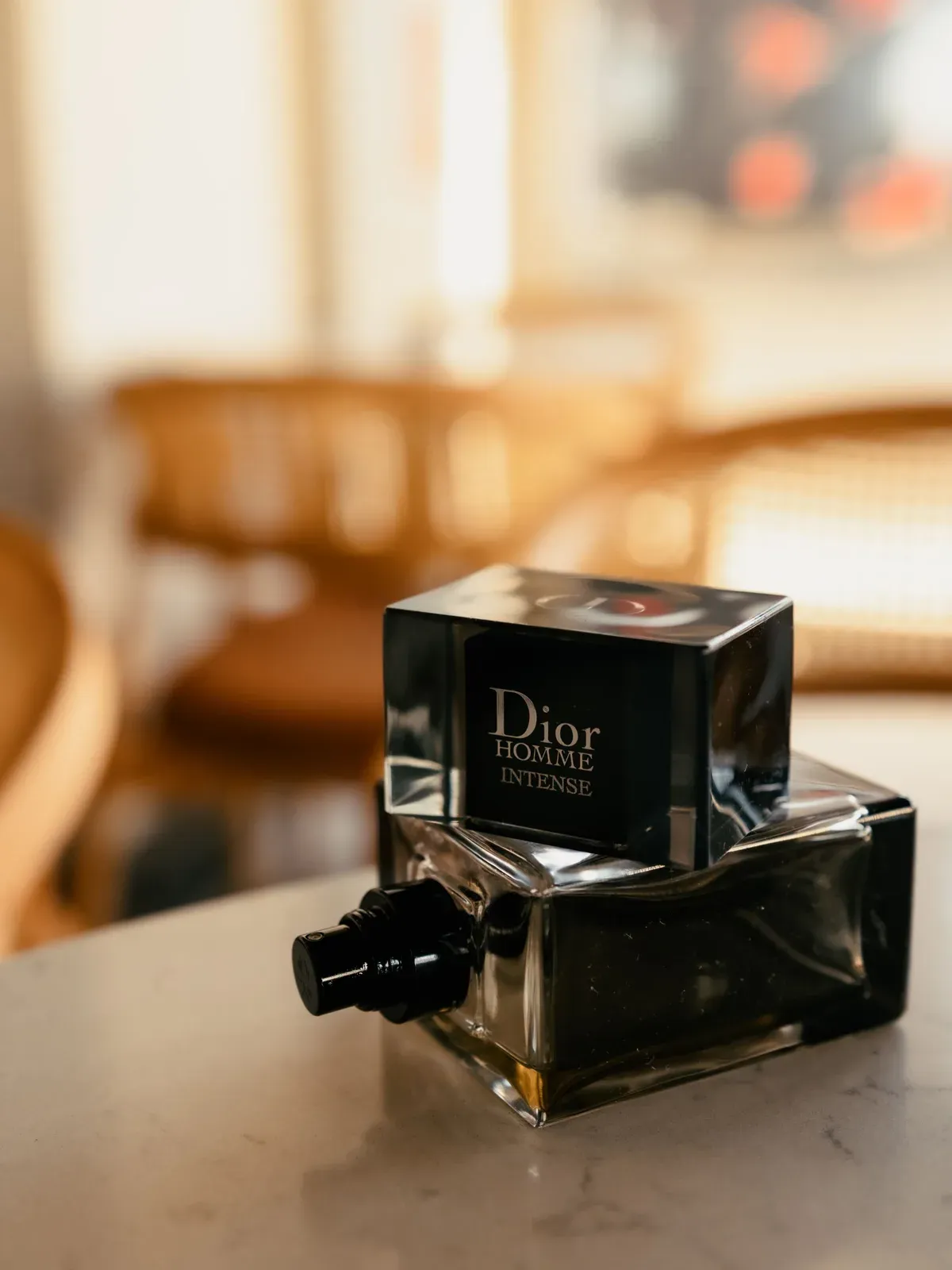 Dior Homme Intense bottle on a marble table